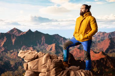 Maceraperestler önlerindeki vadiye ve dağ zirvelerine bakar. Açık arazinin özgürlüğünü hisseder. Genç kaşif tam donanımlı yüksek rakımlı açık hava keşiflerinin tadını çıkarıyor..