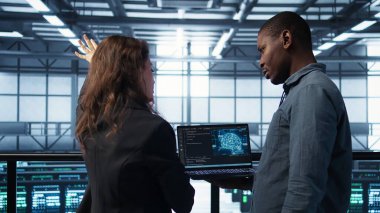 Yazılım geliştiricileri, veri merkezinde sunucu viralizasyonunu yöneten bir dizüstü bilgisayarda yapay zeka teknolojisi kullanıyorlar. Sunucu odasında yapay zeka, ince ayarlı ağ, kamera B kullanarak bilgi işlem uzmanı kodlaması