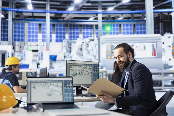 Fotovoltaik fabrikasında çalışan bir müfettiş. Arızalı sistemleri araştırıyor, evrakları okuyor. Güneş panellerini denetleyen, fabrika imalatını azaltan, belgeleri kontrol eden bir denetleyici.