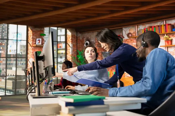 Çağrı merkezi müdürü, müşteri memnuniyetini değerlendirerek çok ırklı takım performansını değerlendiriyor. Müşteri hizmetleri müfettişi çok ırklı iş arkadaşlarını denetliyor.