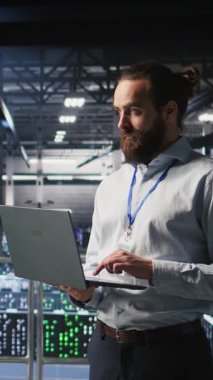 Veri merkezi endüstriyel platformundaki dikey bilgisayar bilimcileri dizüstü bilgisayardaki performans çıktılarını analiz ediyorlar. Sunucu çiftliği bilişim uzmanları ince donanım yapılandırmaları, kamera A üzerinde işbirliği yapıyorlar.