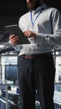 Veri merkezindeki gülümseyen mühendisin dikey video portresi sinir ağı LLM görselleştirmesini izliyor. Neşeli sunucu merkezi bilişim uzmanları teçhizata güç veren makine öğrenme süreçlerini denetliyor, kamera A