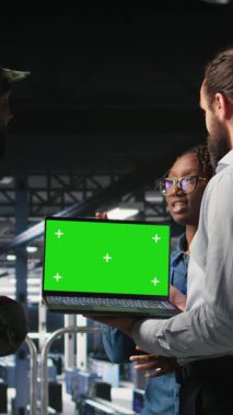 Veri merkezinde dikey video teknolojisi uzmanı ve askeri bilgisayar sistemlerini çökertmek için yeşil ekran dizüstü bilgisayar kullanan iş arkadaşları. Asker ve komut merkezi sunucu odası yöneticileri kroma anahtarı kullanır