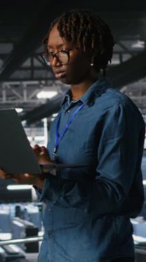 Endüstriyel platformda yürüyen dikey video veri merkezi mühendisi, hataları tespit etmek için ekipman üzerinde tarama yapıyor. Sunucu çiftliği bilişim uzmanları, platformların arıza süresini en aza indirmesini engelliyor