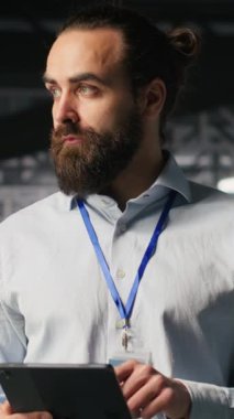 Nöral ağ kodunu ve LLM görselleştirme panellerini inceleyen iş arkadaşlarının yanındaki dikey video sunucu odası teknisyeni. Veri Merkezi Bilişim Uzmanı YZ sistem performansını izleyen meslektaşlarının yanında