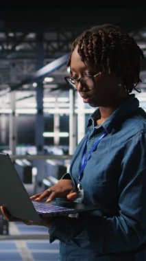 Veri merkezi endüstriyel platformundaki dikey video sistemi yöneticileri dizüstü bilgisayardaki performans çıktılarını analiz ediyorlar. Sunucu merkezi iş arkadaşları dizüstü bilgisayar kullanarak sunucu sondaj ayarlarını inceliyor