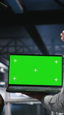 Veri merkezinde dikey video teknolojisi uzmanı ve askeri bilgisayar sistemlerini çökertmek için yeşil ekran dizüstü bilgisayar kullanan iş arkadaşları. Asker ve komut merkezi sunucu odası yöneticileri kroma anahtarı kullanır