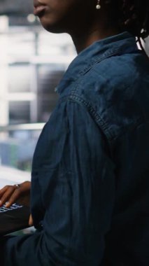 Dikey video sunucusu çiftlik yöneticisi nöral ağ kodunu ve LLM görselleştirme panellerini inceleyen mühendis tarafından yapılan çalışmaları denetliyor. Ekip lideri AI sistem performansını izleyen işçi denetliyor