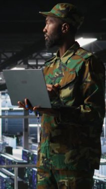 Askeri bilgisayar sistemlerini ve ağları dizüstü bilgisayarla sorun çıkaran veri merkezinde dikey video bilgi teknolojisi uzmanı. Asker Komuta Merkezi sunucu odasında not defteri, kamera A 'yı kullanıyor.