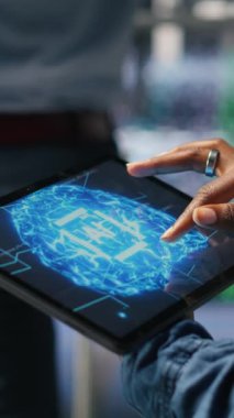 Tablet kullanan veri merkezi mühendisinin dikey görüntüsü. Yapay zeka işleme görevleriyle uğraşan tırların bakımını yapıyor. Sunucu merkezi bilgisayar bilimcisi derin öğrenmeyi destekleyen depolama dizilerini yönetiyor