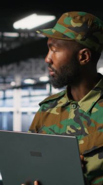 Bilgisayar kullanarak bilgisayar ağlarını siber tehditlere karşı savunan dikey video bilgi işlem uzmanı. Potansiyel ihlalleri veya kötü niyetleri belirlemek için not defteri kullanan askeri komuta merkezi yöneticisi