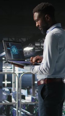 Dikey video sunucusu merkez bilişim uzmanları not defteri kullanarak büyük dil model mimarisini görselleştiriyorlar. Endüstriyel platformdaki veri merkezi sistem yöneticileri görevlerde işbirliği yapıyorlar