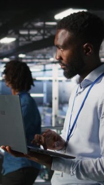 Dikey video sunucu merkezi bilişim uzmanları derin öğrenim eğitim çalışmalarını destekleyen depolama dizilerini yönetir. Endüstriyel platformdaki mühendis yapay zeka işleme sunucularında bakım yapıyor.