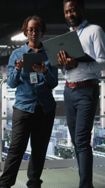 Dikey Veri Merkezi iş arkadaşları laptopta bakım görevleri yapıyor ve en iyi performansı sağlıyor. Tanıları gözden geçiren ve sunucu merkezine yama uygulayan takım arkadaşları, geliştirme