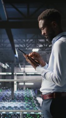 En iyi performansı sağlamak için sistemler üzerinde bakım görevleri yapan dikey video veri merkezi mühendisi. Bilgi İşlem uzmanı tanıları gözden geçiriyor ve sunucu merkezine yama uyguluyor dengeyi ve kamerayı geliştiriyor