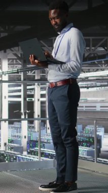 Veri merkezindeki dikey video sistemi yöneticileri sinirsel ağ LLM görüntülemesini izlemek için dizüstü bilgisayar kullanıyorlar. Sunucu merkezi çalışma arkadaşları platformlara güç veren makine öğrenme süreçlerini denetliyor