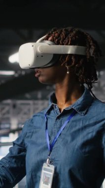 Veri merkezi endüstriyel platformunda sanal gerçeklik teknolojisi kullanarak performans çıktılarını analiz eden dikey video mühendisi. Sunucu merkezi meslektaşları VR kulaklık teknolojisi kullanarak sunucu sondaj ayarlarını inceliyor