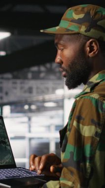 Sunucu odasındaki dikey video askeri, acil operasyonlar sırasında tahliye için coğrafi verileri kullanır. Afet müdahale lojistiğini koordine eden üniformalı askeri veri merkezi personeli