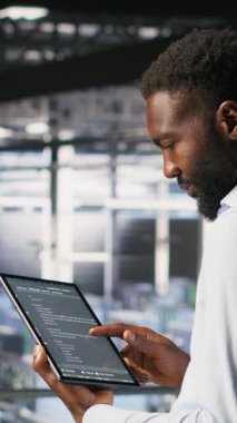 Endüstriyel platform üzerindeki dikey video veri merkezi programcıları kod satırlarını kontrol ediyor, görevlerde işbirliği yapıyorlar. Sunucu merkezi bilişim uzmanları tablet ve tablet kullanarak büyük dil modeli mimarisini görselleştiriyorlar