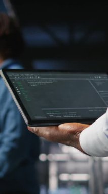 Dikey video, veri merkezi yönetimini makine öğrenme kod gösterge panellerini incelemek için tablet kullanarak kapat. AI altyapı performansını izlemek için aygıt kullanan sunucu çiftliği bilişim uzmanı, kamera A