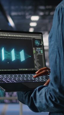 Veri merkezindeki yönetimin dikey videosu LLM görüntülemesini izlemek için dizüstü bilgisayar kullanılarak kapatıldı. Sunucu merkezi IT uzmanı dizüstü bilgisayarla donanım öğrenme işlemini denetliyor