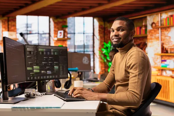 Yenilikçi başlangıç ofisinde bilgisayar kullanan neşeli bilişim teknisyeninin portresi ve uygulama geliştirmek için programlama dilleri. Neşeli yazılım geliştirme ajansı bilişim uzmanı bilgisayarda kodu optimize ediyor