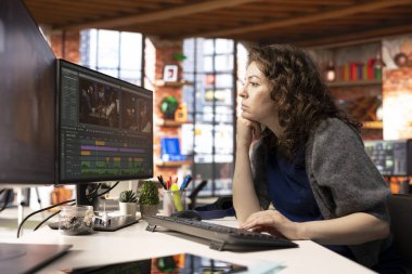 Yaratıcı yazılımla montaj ve video klipleri düzenleyen kadın film yapımcısı, post-prodüksiyonda medya içeriği yaratıyor. Ajans çalışma alanı film yapımı modern araçlar, sinema endüstrisi.