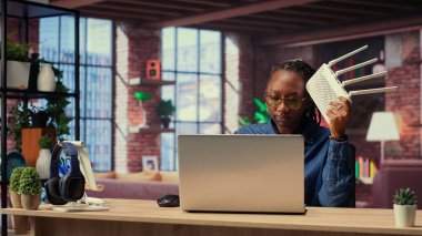 Afrikalı Amerikalı bir kadın kablo çekerek internet sağlayıcısından destek alarak kablosuz internet modemini yeniden başlatıyor. Devam eden Wi-Fi bağlantı sorunları. Kamera B.