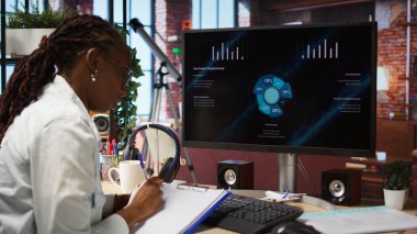 Uzaktan çalışan biri iş konferansını PC monitöründen izliyor, belgelerle ilgili istatistiklere bakıyor. Dairesinde serbest çalışan biri sunuma bakıyor ve evrak dosyalarını kontrol ediyor. Kamera A