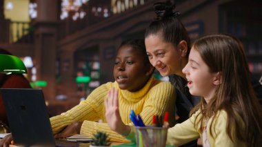 Kütüphanedeki çok ırklı bilginler akıl hocalarıyla uzaktan öğrenim görerek bir ödev için diğer öğrencilerle bir video konferansına katılıyorlar. Öğrenciler online webinar 'a katılıyor. Kamera B.