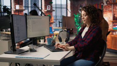 Uygulamaları oluşturmak için bilgisayardaki bilgisayar programlama dillerini kullanan mutlu bir çalışan. Neşeli bilişim uzmanı yazılım geliştirme ajansındaki bilgisayarı kodlamak için kullanıyor, kamera A