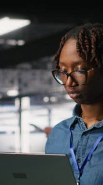 Veritabanı 'ndaki dikey video Mutlu kadın dizüstü bilgisayarda bakım görevleri yapıyor ve en iyi performansı sağlıyor. Mühendislik ekibi tanıları inceliyor ve sunucu odasına yama uyguluyor.