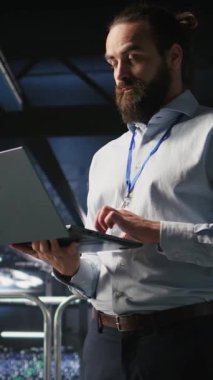 Dikey video veri merkezi yapay zeka LLM görüntülemesini izliyor. Takım çalışması sunucu odası çalışanları işbirliği yapıyor, derin öğrenme süreçlerine güç veren platformları denetliyor, kamera A