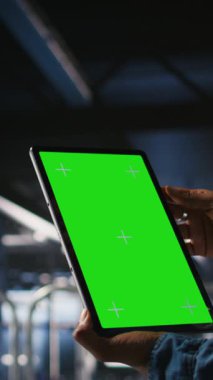 Yalıtılmış ekran tableti kullanarak sunucu merkezi yönetiminin dikey videosu AI LLM görselleştirmesini gözden geçiren meslektaşın yanında. Veri merkezi çalışanı makine öğrenme sistemlerini izlemek için model aygıtı kullanıyor