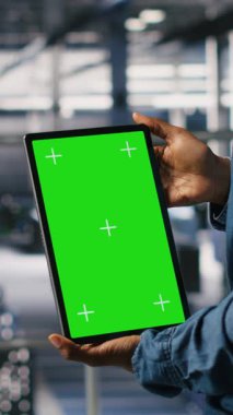 Dikey Veri Merkezi mühendisleri yeşil ekran tableti kullanarak sinirsel ağ LLM görselleştirmesini izliyorlar. Sunucu çiftliği bilişim uzmanları krom anahtar kullanarak güç makinelerinin öğrenme süreçlerini denetliyor