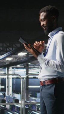 Veri merkezindeki endüstriyel platformda, cihazlardaki performans çıktılarını analiz eden dikey video yazılım geliştiricileri. Sunucu odası bilişim uzmanları ana bilgisayar yapılandırmaları ve kamera üzerinde işbirliği yapıyorlar.