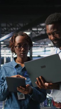 Dikey Veri Merkezi yöneticileri AI LLM görselleştirmelerini gözden geçirmek için dizüstü bilgisayar kullanıyorlar. Afrika kökenli Amerikan bilişim uzmanları sinirsel ağların çıktılarını analiz etmek için aygıt kullanırlar.