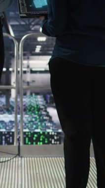 Sinir ağı AI LLM görselleştirmesi kullanılarak yönetimin yaptığı işleri denetleyen dikey video Veri Merkezi yöneticisi. Sunucu ekip lideri ve işçi, platformlara güç veren makine öğrenme süreçlerini denetliyor