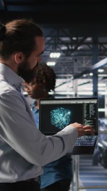 Yüksek teknoloji sunucu tesisinde yapay zeka işlemlerini yöneten dikey video askeri personel. Ordu teknoloji uzmanları iletişim sistemlerini ve kamera A 'yı denetlemek için yapay zeka kullanıyor.