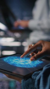 Tablet kullanan veri merkezi mühendisinin dikey görüntüsü. Yapay zeka işleme görevleriyle uğraşan tırların bakımını yapıyor. Sunucu merkezi bilgisayar bilimcisi derin öğrenmeyi destekleyen depolama dizilerini yönetiyor