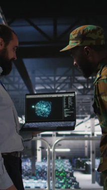 Dikey video askeri operatörü ve ordu veri merkezinde bilişim uzmanı özerk savunma sistemlerini yönetmek için yapay zeka kullanıyor. Asker ve programcı, stratejik tehdit tespiti için yapay zeka kullanıyor. Kamera A