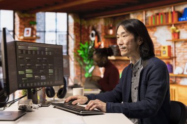 Yenilikçi bir ofiste çalışan kıdemli teknisyen uygulama yapmak için programlama dilleri kullanıyor. Tecrübeli yazılım geliştirme ajansı IT CTO yöneticisi bilgisayarda kodu optimize ediyor