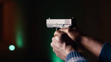 Atış poligonu müşterisi silahla ateş ediyor, uzun menzilli hedeflerle çatışmaya giriyor. Afrika kökenli Amerikalı adam ateş ederek öldürücü silah kullanıyor. Koruyucu ekipman takıyor. B kamerasını kapatın.