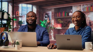 Evlerindeki Afrikalı Amerikalı çift, verimliliği ve kariyer gelişimini artırmak için takım çalışması ve dijital online araçlar kullanarak bir proje üzerinde işbirliği yapıyor. Bağımsız görevleri çözmek. Kamera B.