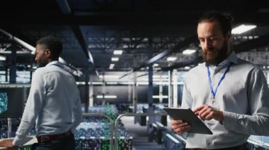 Sunucu odası teknisyeni nöral ağ kodunu ve LLM görselleştirme panelini inceleyen iş arkadaşlarının yanında. Veri Merkezi bilişim uzmanı, AI sistem performansını izleyen iş arkadaşlarının yanında, kamera A