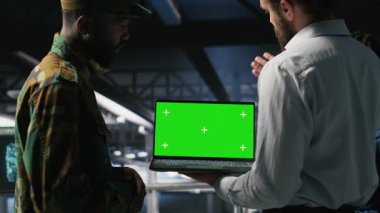 Ordu teknoloji uzmanı ve iş arkadaşları askeri bilgisayar sistemlerini çökertmek için yeşil ekran dizüstü bilgisayar kullanıyorlar. Asker ve komuta merkezi sunucu odası yöneticileri kroma anahtar defteri, kamera B