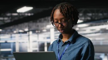 Veri merkezi endüstriyel platformundaki sistem yöneticileri dizüstü bilgisayardaki performans çıktılarını analiz ediyorlar. Sunucu merkezi iş arkadaşları not defteri, kamera B kullanarak sunucu sondaj ayarlarını inceliyor