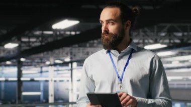 Sunucu odası teknisyeni nöral ağ kodunu ve LLM görselleştirme panelini inceleyen iş arkadaşlarının yanında. Veri merkezi bilişim uzmanı, YZ sistem performansını izleyen iş arkadaşlarının yanında, kamera B