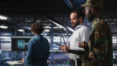 Komuta merkezi sunucu odasındaki ordu teknisyeni bilgisayar kullanarak bilişim sistemlerini kuruyor. Bilgisayar ağlarını ve bilgi sistemlerini denetleyen askeri veri merkezi yönetimi, kamera A