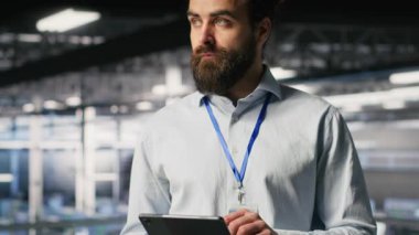 Neşeli veri merkezi idarecisi tablet üzerinde bakım görevleri yapıyor ve en iyi performansı sağlıyor. Bilgi İşlem uzmanı tanıları gözden geçiriyor ve sunucu merkezi dişlisine yama uyguluyor, kamera B